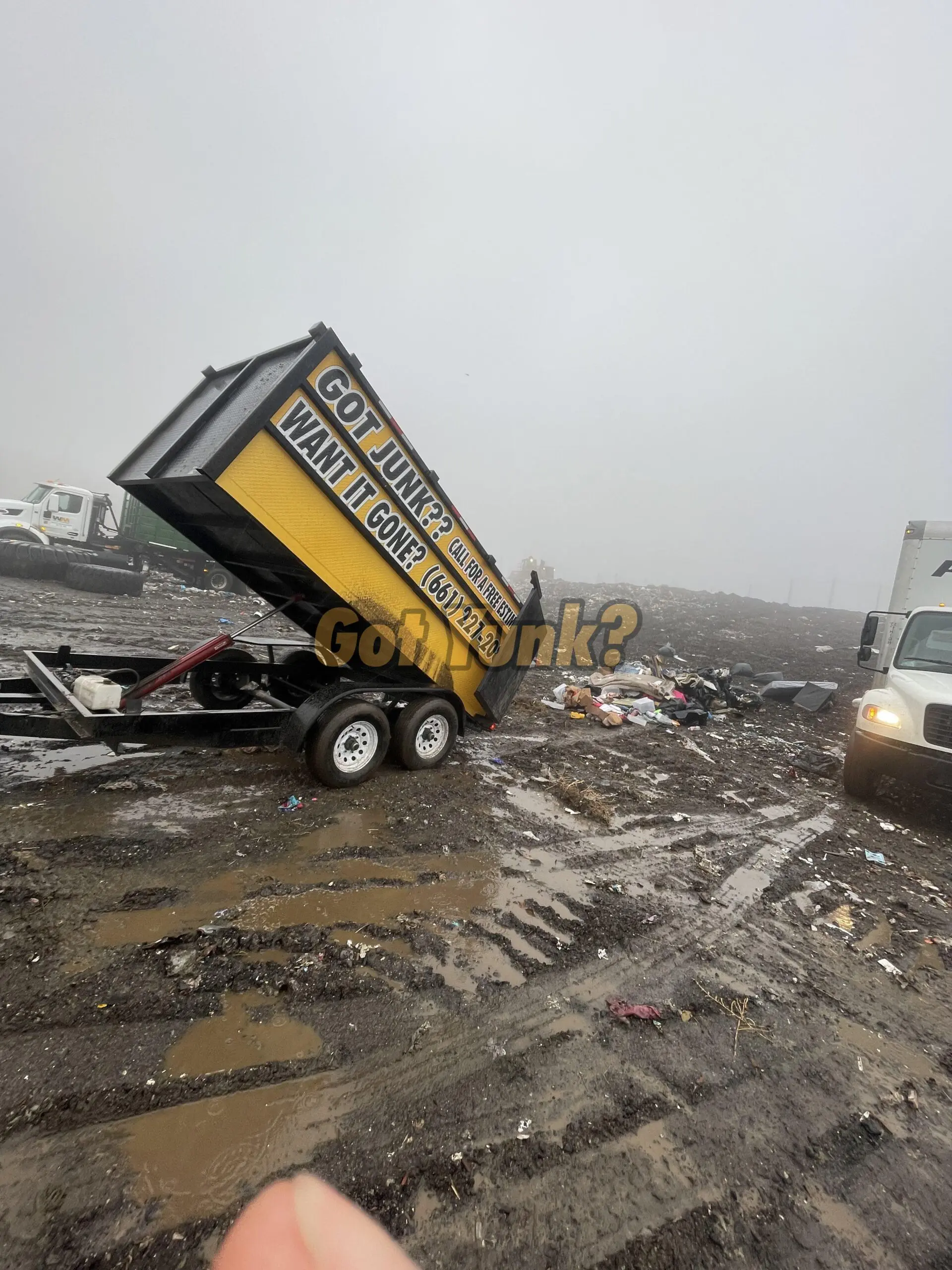 Junk removal worker in Palmdale, CA loading trash and debris into trailer during a cleanup job.