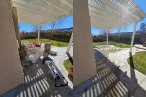 Backyard junk removal in Santa Clarita, CA ? before and after showing toilet, chair, and moving boxes removed from patio under pergola.