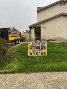 Junk removal trailer and yard sign promoting clutter-free homes.