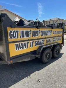 Loaded junk and concrete trailer on-site for removal services in Palmdale, CA.