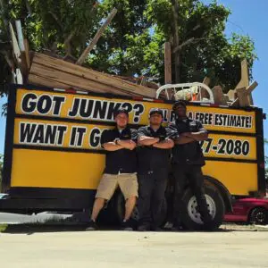 Affordable Hauling Services crew posing in front of a junk trailer in Quartz Hill, CA.