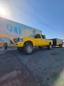 Junk removal truck parked in front of the Palmdale mural, promoting clutter-free living.