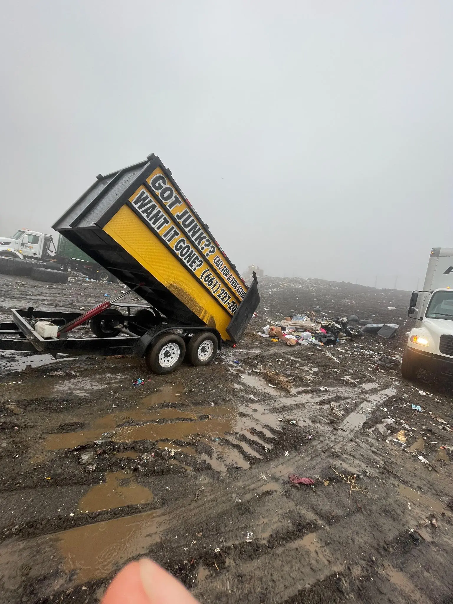 Dump trailer unloading junk at a muddy landfill in Lancaster, CA.