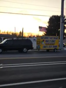 Junk removal trailer in motion at sunset in Palmdale, California.