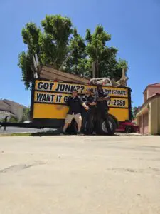 Affordable Hauling Services crew standing in front of fully loaded trash trailer in Quartz Hill.