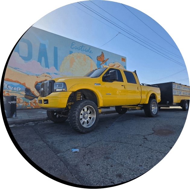 Affordable Hauling yellow work truck and dump trailer in Palmdale California used for junk and trash removal services.